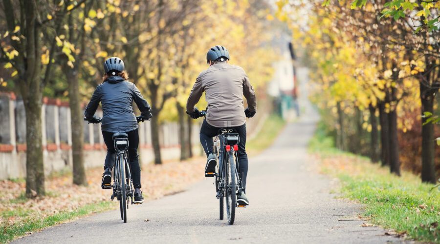 Kobieta i mężczyzna jadą na rowerach przez jesienny park