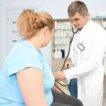 Lekarz bada pacjentkę z otyłością