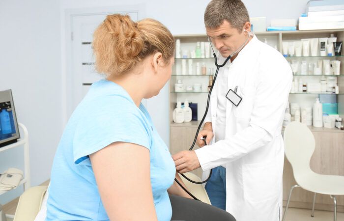 Lekarz bada pacjentkę z otyłością